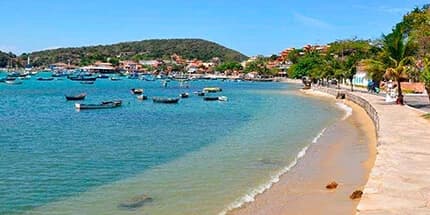 Orla tranquila de Búzios com barcos ancorados na baía